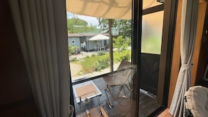 A room with a sliding glass door leading to an outdoor patio area with a table, chairs, and a small garden. - R GARDEN (Yamanakako)
