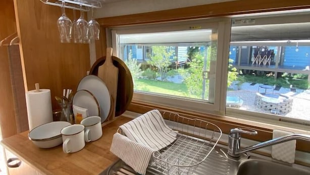 A kitchen with a sink, a drying rack, and a window with a view of the outside. - R GARDEN (Yamanakako)