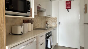 A modern kitchen with a microwave, toaster, sink, and cabinets. - Beachfront Studio, Views, Best Location (Dee Why)
