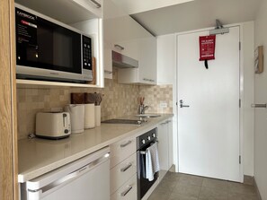 Eine moderne Küche mit Mikrowelle, Toaster, Spüle und Schränken.