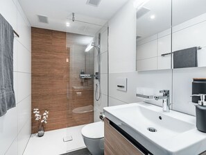 Ein modernes Badezimmer mit Dusche, Toilette und Waschbecken.
