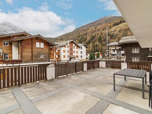 Ein Innenhof mit Holzzaun, Tisch und Gebäuden mit Balkonen.