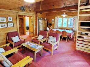 A cozy cabin interior with wooden walls, a dining area, and a television. - La Sapinière Appartement/Fewo 8-Bettwohnung by Interhome (Saas-Fee)