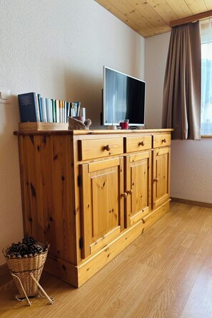 Eine Holzkabine mit mehreren Schubladen und einem Fernseher darauf.