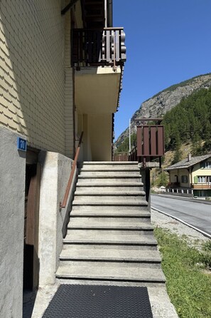 A set of concrete steps leading to a building with a metal railing and a blue sign indicating the number 10.