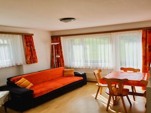 A living room with a sofa, a table, and chairs. - Apartments Atlas Appartement/Fewo Atlas 3 by Interhome (Saas-Grund)