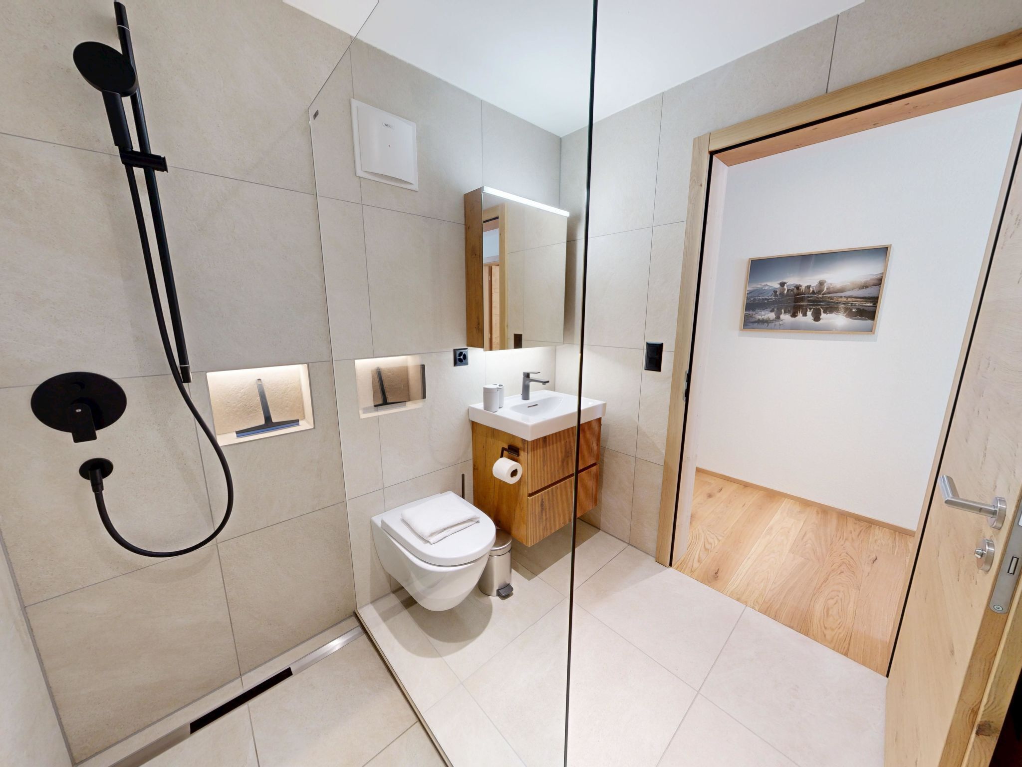 Ein modernes Badezimmer mit Dusche, Toilette, Waschbecken und Spiegel.