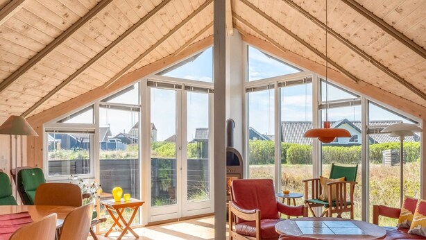 A spacious room with a high ceiling, large windows, and a fireplace. - "Eldmar" - 500m from the sea by Interhome (Harboøre)