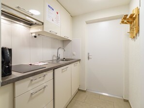 Eine kleine Küche mit Spüle, Arbeitsplatte und Schränken.
