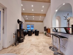 A spacious living area with a fireplace, seating, and a view of the outdoors. - Zum Lerch Appartement/Fewo 8-Bettwohnung by Interhome (Saas-Fee)