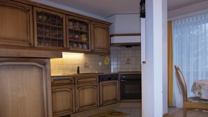 Una cocina con armarios de madera, lavavajillas y salpicadero de azulejos.