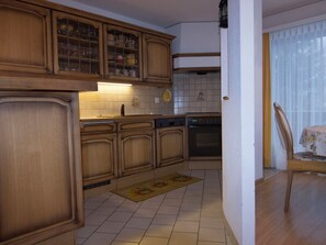 A kitchen with wooden cabinets, a dishwasher, and a tiled backsplash. - Waldrain 2 Appartement/Fewo 4-Bettwohnung by Interhome (Saas-Fee)