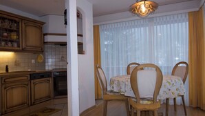 Una cocina con armarios de madera y un comedor con mesa y sillas.