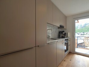 A modern kitchen with a large window, a built-in oven, and a marble countertop. - Britannia Appartement/Fewo 4-Bettwohnung by Interhome (Saas-Fee)