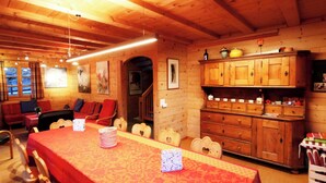 A wooden interior with a dining table, chairs, a sofa, and a cabinet. - Les Mélèzes Appartement/Fewo 8-Bettwohnung by Interhome (Saas-Fee)