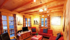A wooden cabin interior with a sofa, chairs, a table, and a television. - Les Mélèzes Appartement/Fewo 8-Bettwohnung by Interhome (Saas-Fee)