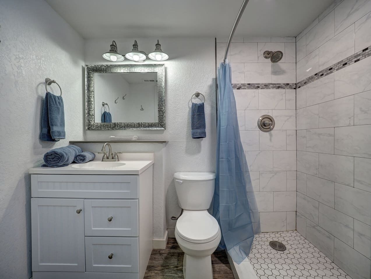 Un bagno con lavandino, WC e doccia.