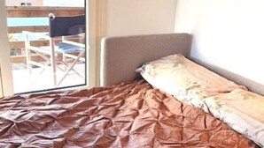 A bedroom with a bed, a window, and a view of a building and mountains. - Sonnenhang 2 Appartement/Fewo Apartment Nr. 2 by Interhome (Saas-Fee)