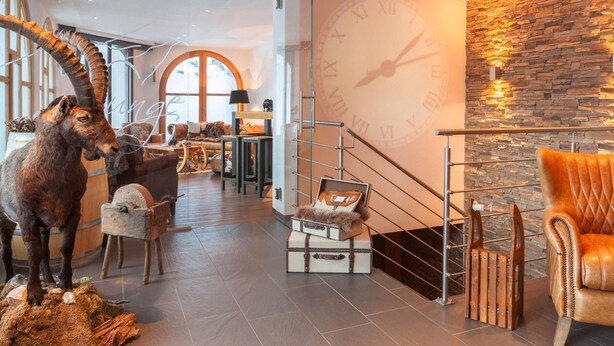 Ein modernes Interieur mit einer Steinwand, einer großen Uhr und einer Treppe.