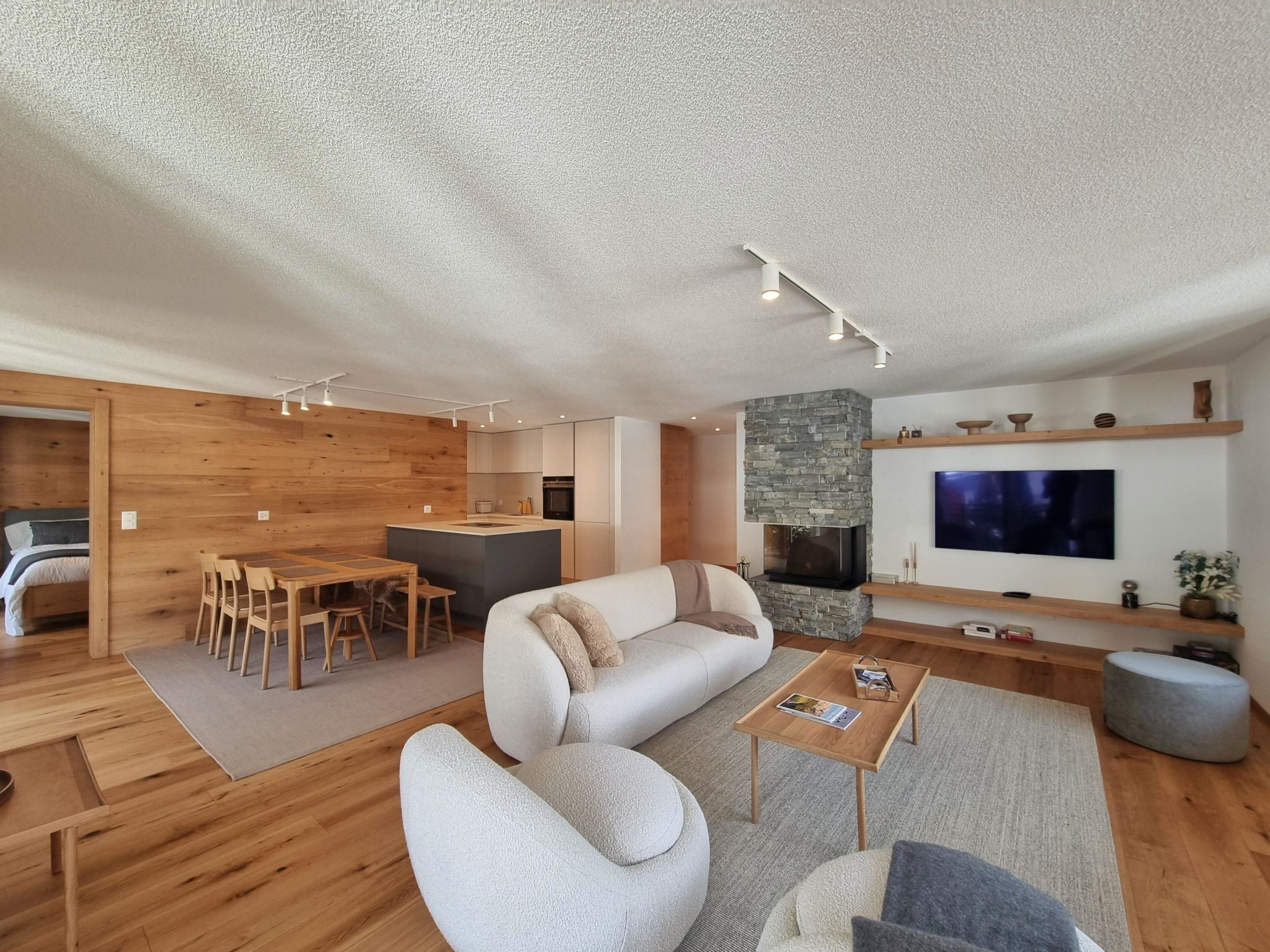 Ein modernes Wohnzimmer mit Sofa, Couchtisch und Fernseher.