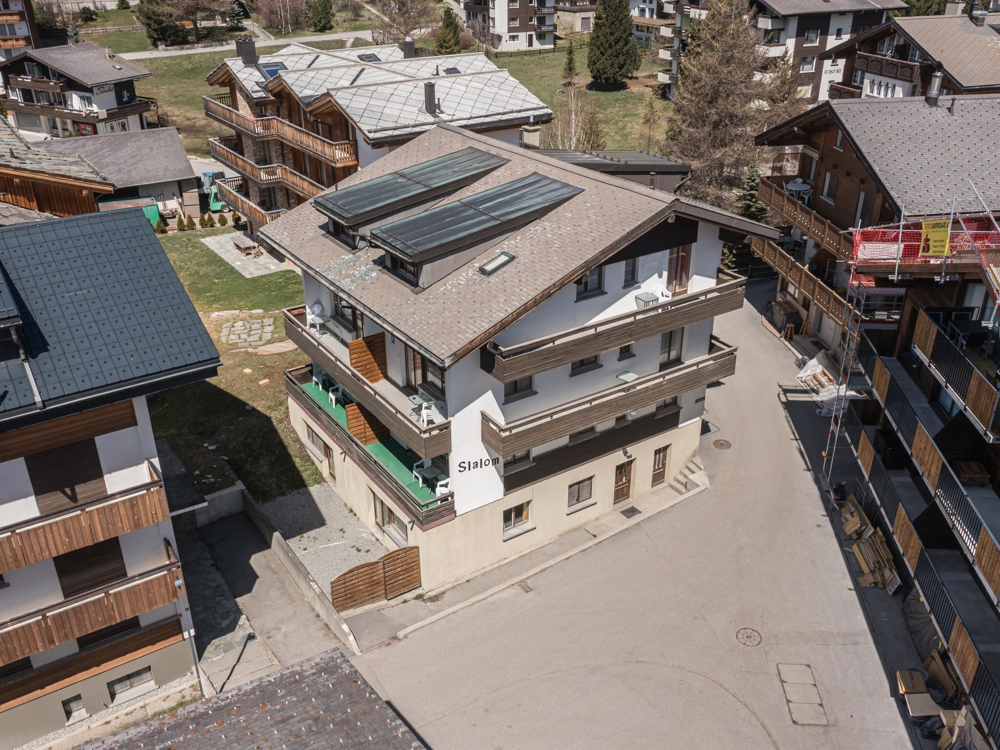 Un immeuble à plusieurs étages, doté d’un toit plat, de panneaux solaires et de balcons.