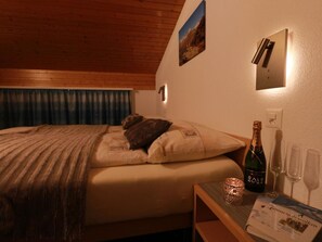 A hotel room with a bed, a bottle of champagne, and glasses on a small table. - Azur Appartement/Fewo 4-Bettwohnung Nr. 10 by Interhome (Saas-Fee)