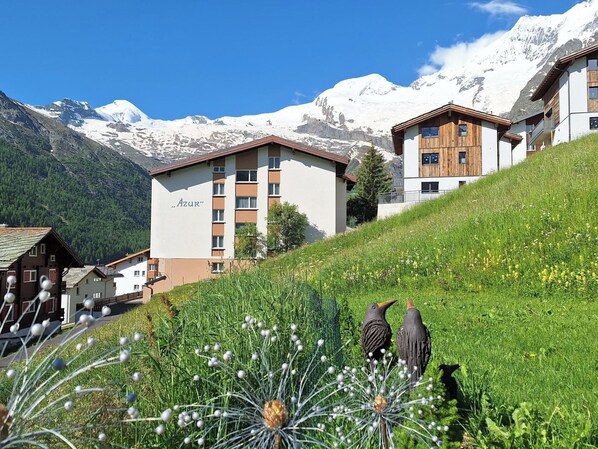 Un hôtel au design moderne, avec une vue sur les montagnes et une colline verdoyante.