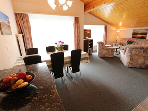 A dining area with a table set for four, a sofa, and a television in the background. - Azur Appartement/Fewo 4-Bettwohnung Nr. 10 by Interhome (Saas-Fee)