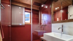 A modern bathroom with a glass shower enclosure, a white sink, and a wooden vanity. - Chalet Wilhelmina Appartement/Fewo, Dusche und Bad, WC, 8-Bettwohnung by Interhome (Arosa)