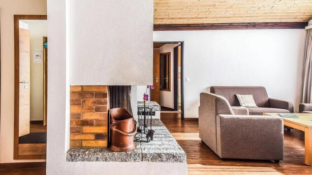 A modern living room with a fireplace, a sofa, and a coffee table. - Haus Camillo Appartement/Fewo 4-Bettwohnung Nr. 16 by Interhome (Saas-Fee)