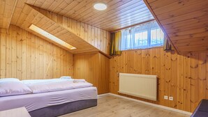 A room with wooden walls, a bed, a radiator, and a window with curtains. - Haus Slalom Appartement/Fewo Apt #7 by Interhome (Saas-Fee)