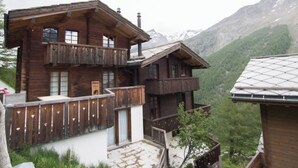 A wooden chalet with a balcony, set against a mountainous backdrop. - Mountain Village 11 Appartement/Fewo 6-Bettwohnung by Interhome (Saas-Fee)