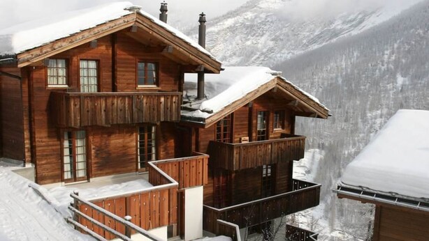 A wooden chalet with a balcony, a snow-covered roof, and a mountainous backdrop. - Mountain Village 11 Appartement/Fewo 6-Bettwohnung by Interhome (Saas-Fee)
