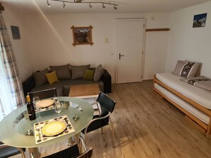 Ein Wohnzimmer mit Glastisch, einer Couch und einer Tür.