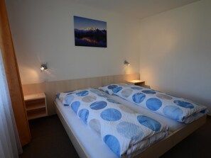 Ein Schlafzimmer mit einem Bett, zwei Nachttischen, einer Wandlampe und einem Bild.