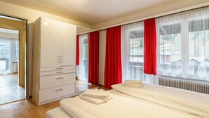 Ein Hotelzimmer mit einem Bett, einem Kleiderschrank und einem Vorhangfenster.