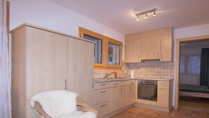 Una cocina compacta con comedor, un amplio armario y una silla con cojín mullido.