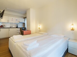 A hotel room with two beds, a kitchenette, and a small dining area. - Haus City Studio Apt #5 by Interhome (Saas-Grund)