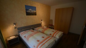 Una camera da letto con un letto matrimoniale, due comodini, un armadio e un quadro appeso al muro.