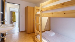 A bunk bed with a wooden frame, a white sink, and a wardrobe in a room with wooden flooring. - Haus City Appartement/Fewo Apt #3 by Interhome (Saas-Grund)