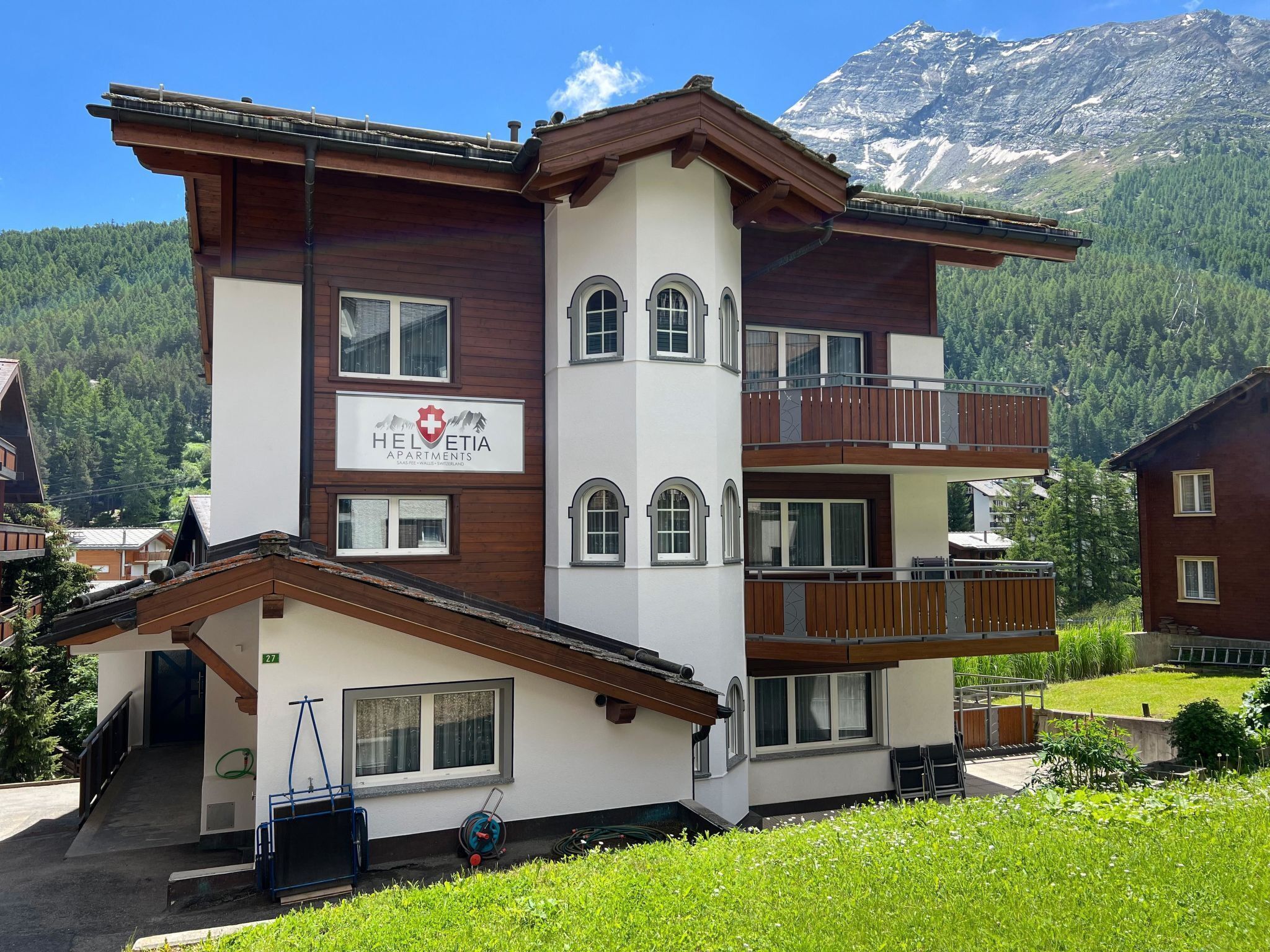 Ein mehrgeschossiges Gebäude mit einem Schild für 'Helvetia Apartments'.