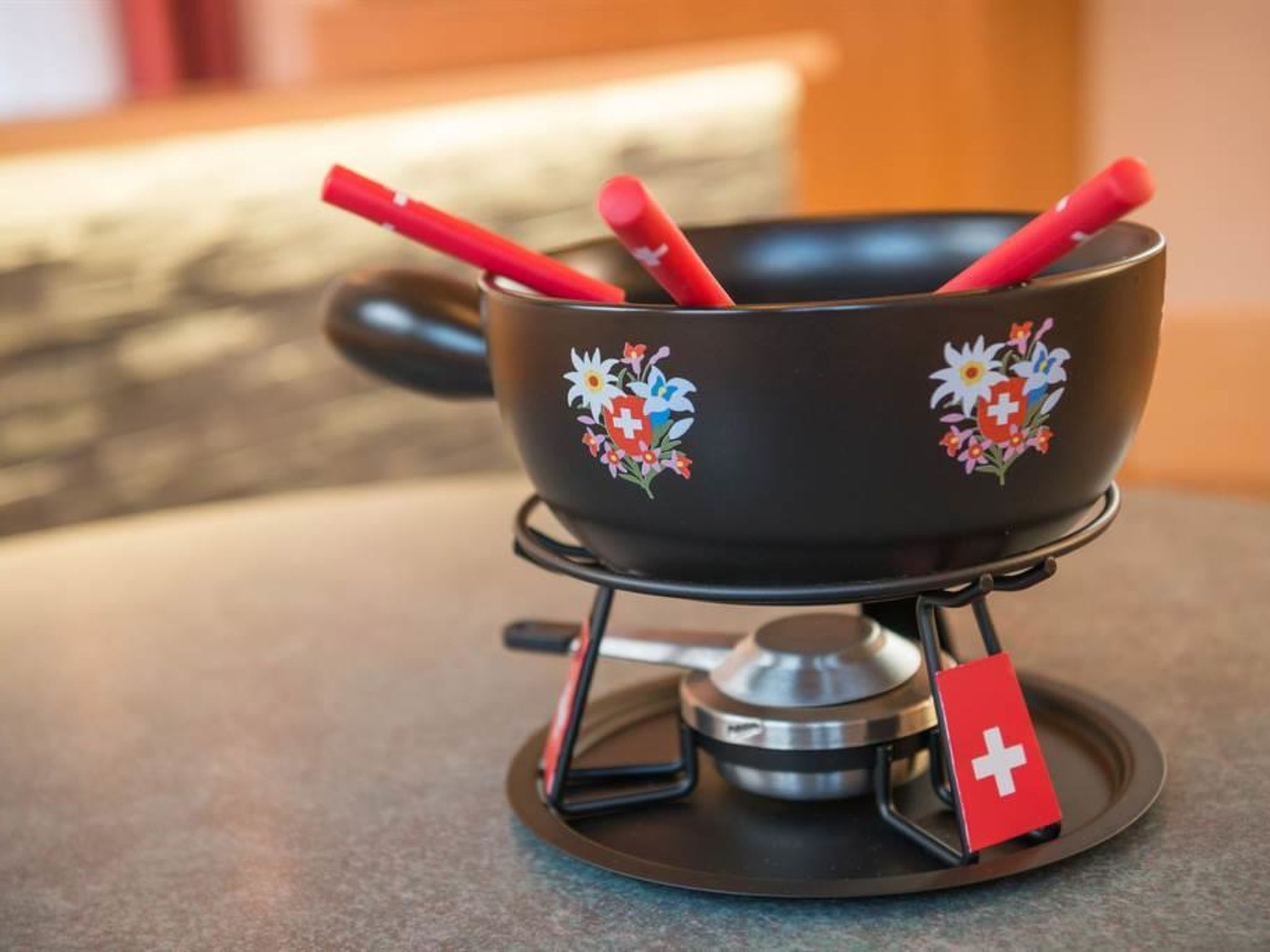 Un réchaud portable avec une casserole dessus, un drapeau rouge et une cuillère.