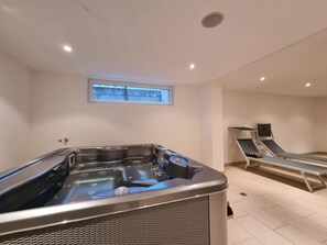 A spa room with a hot tub, two massage chairs, and a window. - Mountain Village Residence Appartement/Fewo Appartement/Fewo by Interhome (Saas-Fee)