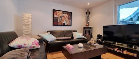 Una sala de estar moderna con sofá, mesa de centro y televisor.