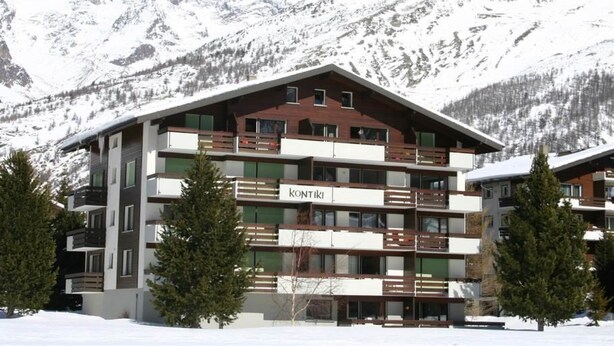 A multi-story hotel with balconies, set against a snowy mountain backdrop. - Kontiki Appartement/Fewo 4-Bettwohnung Kontiki L by Interhome (Saas-Fee)