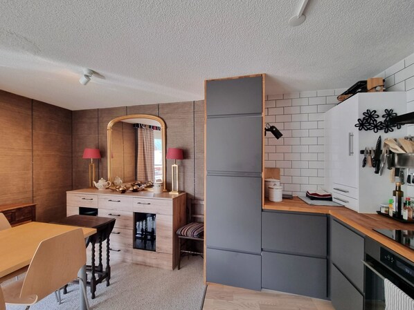 A modern kitchen with a built-in stove, white cabinets, and a wooden dining area. - Daniela 2 Appartement/Fewo Appartement/Fewo by Interhome (Saas-Fee)