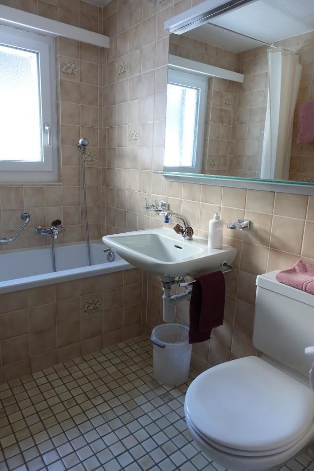 Ein Badezimmer mit Badewanne, Waschbecken, Toilette und einem Fenster.