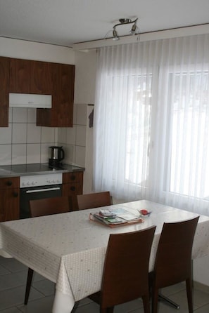 A kitchen with a dining table, chairs, a kettle, and a coffee maker. - Mischi 9 & 10 Appartement/Fewo 5-Bettwohnung Nr. 9 by Interhome (Saas-Fee)
