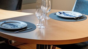 Een ronde eettafel met een bord, twee wijnglazen en een vork.
