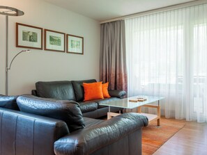 A modern living room with a leather sofa, a glass coffee table, and a floor lamp. - Dolce Vita Appartement/Fewo 2-Bettwohnung Südlenz by Interhome (Saas-Fee)